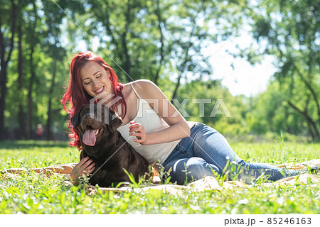 Young attractive woman hugs her dog in the park. 85246163