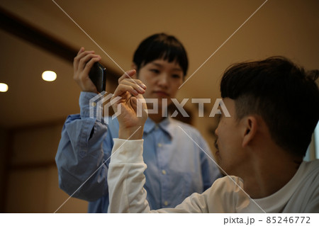 男性のスマートフォンを取り上げる女性 男性のスマートフォンを取り上げる女性 85246772