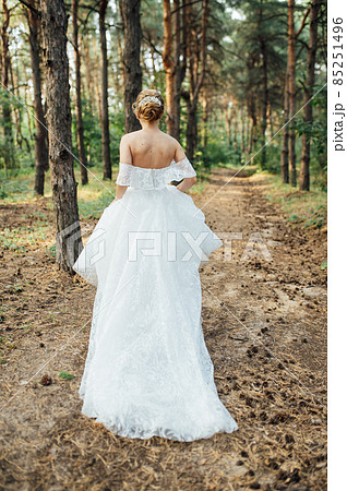 Beautiful wedding bride running in the garden 85251496