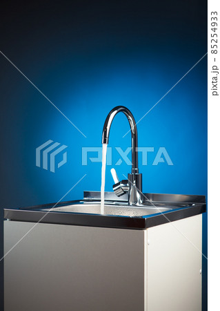 mixer tap with flowing water, blue background mixer tap with flowing water, blue background 85254933