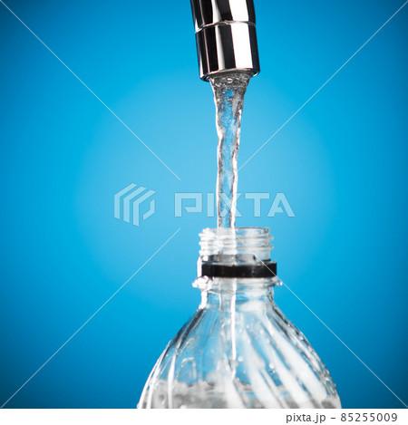 pouring a bottle of water from mixer tap pouring a bottle of water from mixer tap 85255009