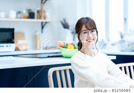 キッチンでくつろぐメガネの女性 85256085