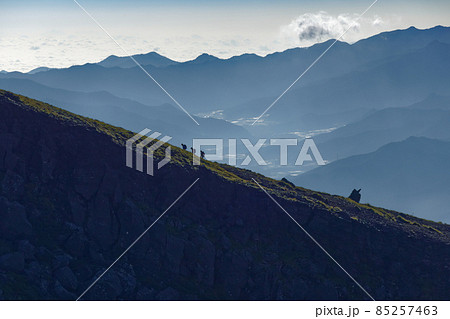 八ヶ岳連峰・硫黄岳稜線を行く登山者と朝の山並み 85257463