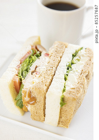 美味しいスモークチキンサンドとポテトグラタンサンドとコーヒー 85257687