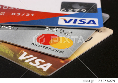 Three bank credit cards with Visa and Mastercard logos on a black background Three bank credit cards with Visa and Mastercard logos on a black background 85258079