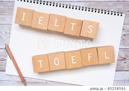 「IELTS」「TOEFL」と書かれた積み木とペンとノート 85258591