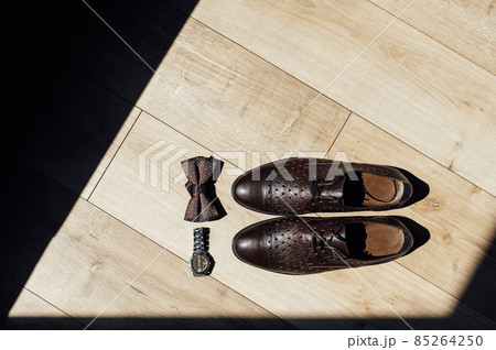 Close up of modern man accessories. Black bowtie, leather shoes and watches 85264250