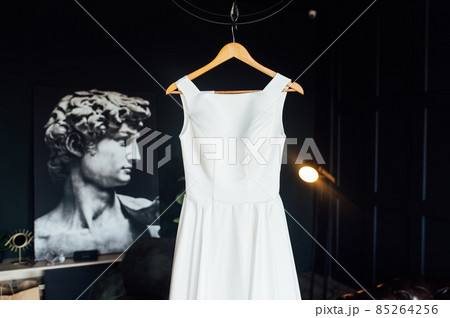 White dress of the bride before the wedding. It is located in a dark room 85264256