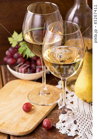 Wine and grapes in vintage setting on wooden table. Wine and grapes in vintage setting on wooden table. 85267411