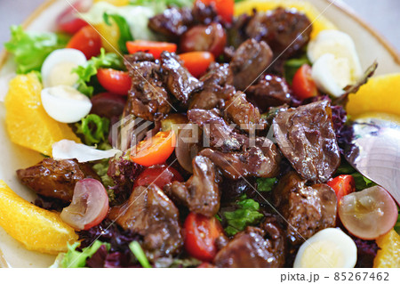 pieces of roasted meat on fresh vegetables with quail eggs.  85267462