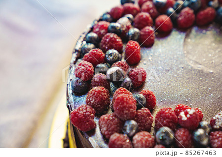 part of a round chocolate cake with fresh raspberries and blueberries part of a round chocolate cake with fresh raspberries and blueberries 85267463