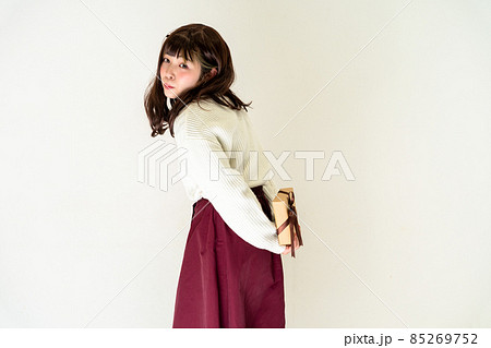 プレゼントを後ろ手に持って立っている女性 プレゼントを後ろ手に持って立っている女性 85269752