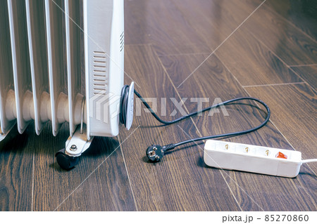 the electrical plug is on the floor next to the oil-filled portable heater. It's cold at home and electricity is expensive. 85270860