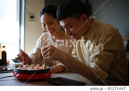 自宅でたこ焼きを作る夫婦 85271447