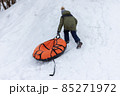 A child is tubing down the hill. Fun in the snow to ride down the hill on a tubing ice cheesecake. Earthly joyful fun, warm clothes. Boy is riding a tubing. Winter fun for children. High quality photo 85271972