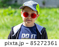 The boy in the cool red glasses is watching. Sunny. High quality photo 85272361