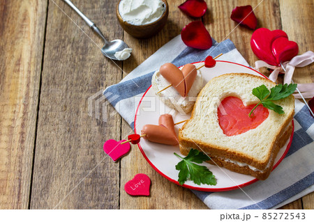 Breakfast for valentine's day or mother's day. Toast with salmon and cheese with the inscription that I love you, on a rustic table.  85272543