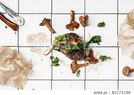 Grilled beef steak with chanterelles on white tiles background Grilled beef steak with chanterelles on white tiles background 85273196