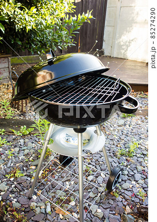 庭に置かれたバーベキュー用の蓋の付いた新しいコンロ 85274290