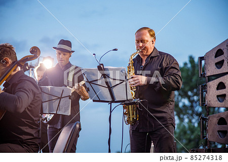 Saxophone player playing in orchestra on the street Saxophone player playing in orchestra on the street 85274318