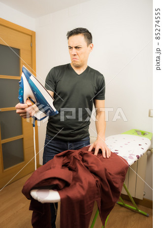 Man who does not know how to iron clothes. 85274555