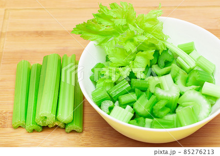 Fresh Chopped Celery Slices in White Bowl with Celery Sticks on Bamboo Cutting Board Fresh Chopped Celery Slices in White Bowl with Celery Sticks on Bamboo Cutting Board 85276213