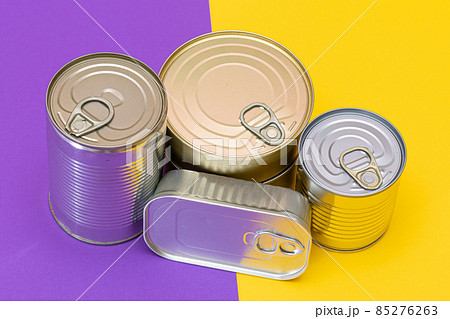 A Group of Stacked Tin Cans with Blank Edges on Split Yellow and Violet Background 85276263
