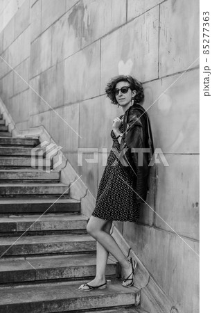 young woman standing on stairs against a wall 85277363