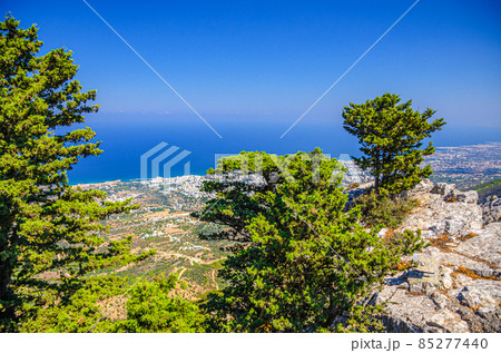 Aerial view of Kyrenia District valley with Kyrenia Girne city and Mediterranean sea in sunny day, green trees on rock of Kyrenia Girne mountains Aerial view of Kyrenia District valley with Kyrenia Girne city and Mediterranean sea in sunny day, green trees on rock of Kyrenia Girne mountains 85277440