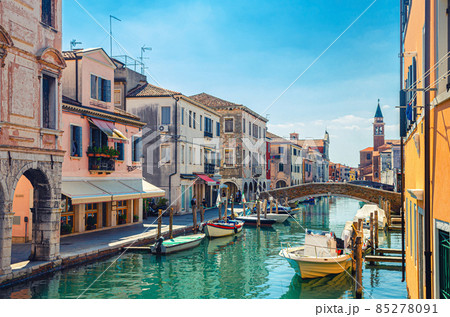 Chioggia cityscape with narrow water canal Vena with moored multicolored boats 85278091