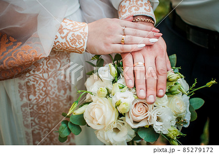 Bride and groom hands with flower bouquet Bride and groom hands with flower bouquet 85279172