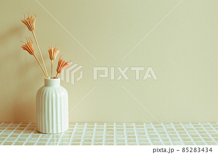 Vase of pink dry flowers on ceramic mosaic tile table. beige wall background. home interior Vase of pink dry flowers on ceramic mosaic tile table. beige wall background. home interior 85283434