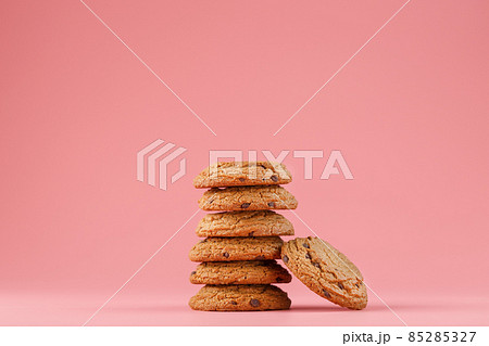 Oatmeal cookies with chocolate are stacked on a pink background. Oatmeal cookies with chocolate are stacked on a pink background. 85285327