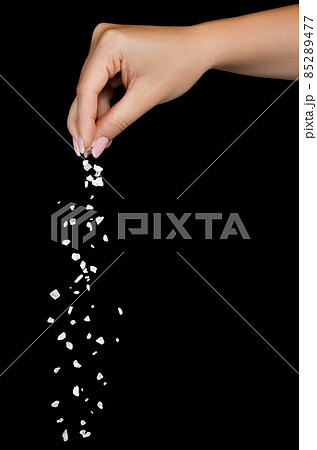 Sea salt falling from finger tips isolated on black 85289477