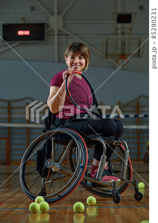 Disabled young woman on wheelchair playing tennis on tennis court 85290231