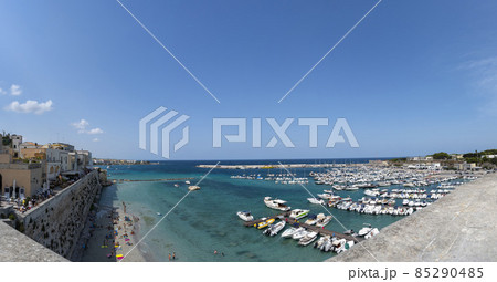 Otranto, Puglia, Italy. August 2021. Amazing view from the top of a panoramic point over the town: the gaze passes from the town to the sea and the marina in this large panoramic format photo. 85290485