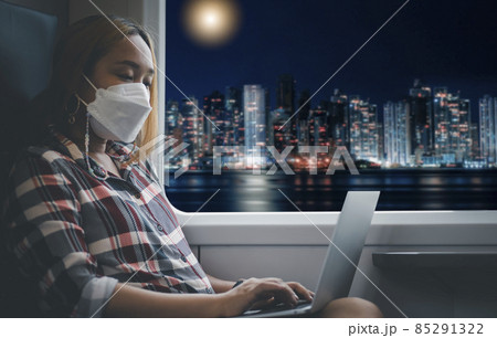 Businesswoman wearing a mask and working on laptop on a train,Big data analytics and business intelligence with chart and graph icons, Team success, HR Human, Business success and teamwork concept. 85291322