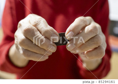 hands of old country woman are holding candy 85294161