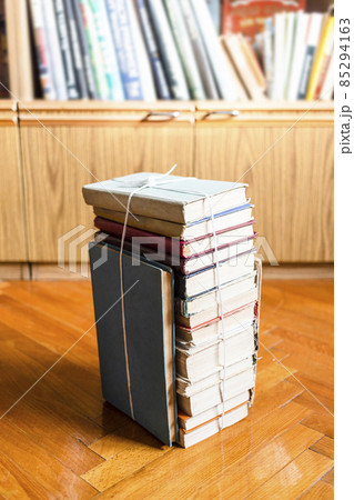 stack of old book tied with twine on wooden floor 85294163