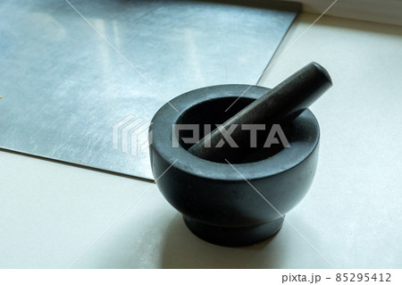 Dark stone kitchen mortar on the countertop 85295412