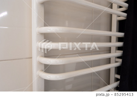 White ladder bathroom radiator and dark towel 85295413