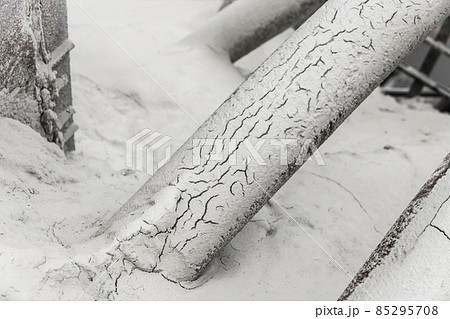 Old pipe on the barrel. White fertilizers or sand pipeline filtration of chemical and mineral minerals. Abandoned industrial plant Old pipe on the barrel. White fertilizers or sand pipeline filtration of chemical and mineral minerals. Abandoned industrial plant 85295708