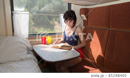 A pregnant woman going on vacation reads a book in her soft compartment of the car A pregnant woman going on vacation reads a book in her soft compartment of the car 85298405