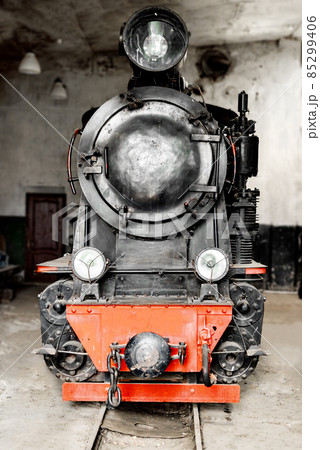 An old vintage steam train locomotive on a railway 85299406