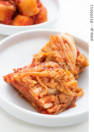 白背景の白いお皿に盛ったキムチとカクテキ 85300011