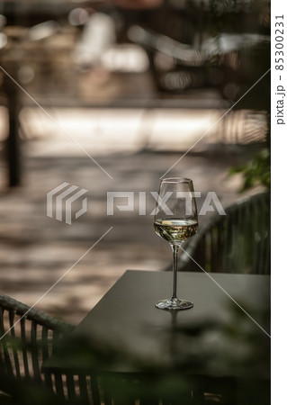 Glass of refreshing cold white wine on a table in summer grade terrace. Selective focus Glass of refreshing cold white wine on a table in summer grade terrace. Selective focus 85300231