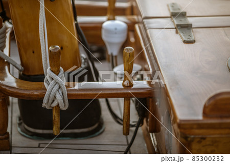 Detail closeup of wooden cleats with nautical moored ropes of sailboat. Detail closeup of wooden cleats with nautical moored ropes of sailboat. 85300232