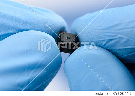 Tiny cell phone camera module in hands. Camera sensor technology research. Tiny cell phone camera module in hands. Camera sensor technology research. 85300419