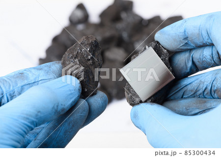Solar panel and lump of coal in scientist hands. Fossil fuel transition to renewable energy research Solar panel and lump of coal in scientist hands. Fossil fuel transition to renewable energy research 85300434