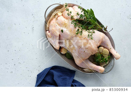 Fresh Raw chicken with herbs sage, rosemary, oregano. Top view. 85300934